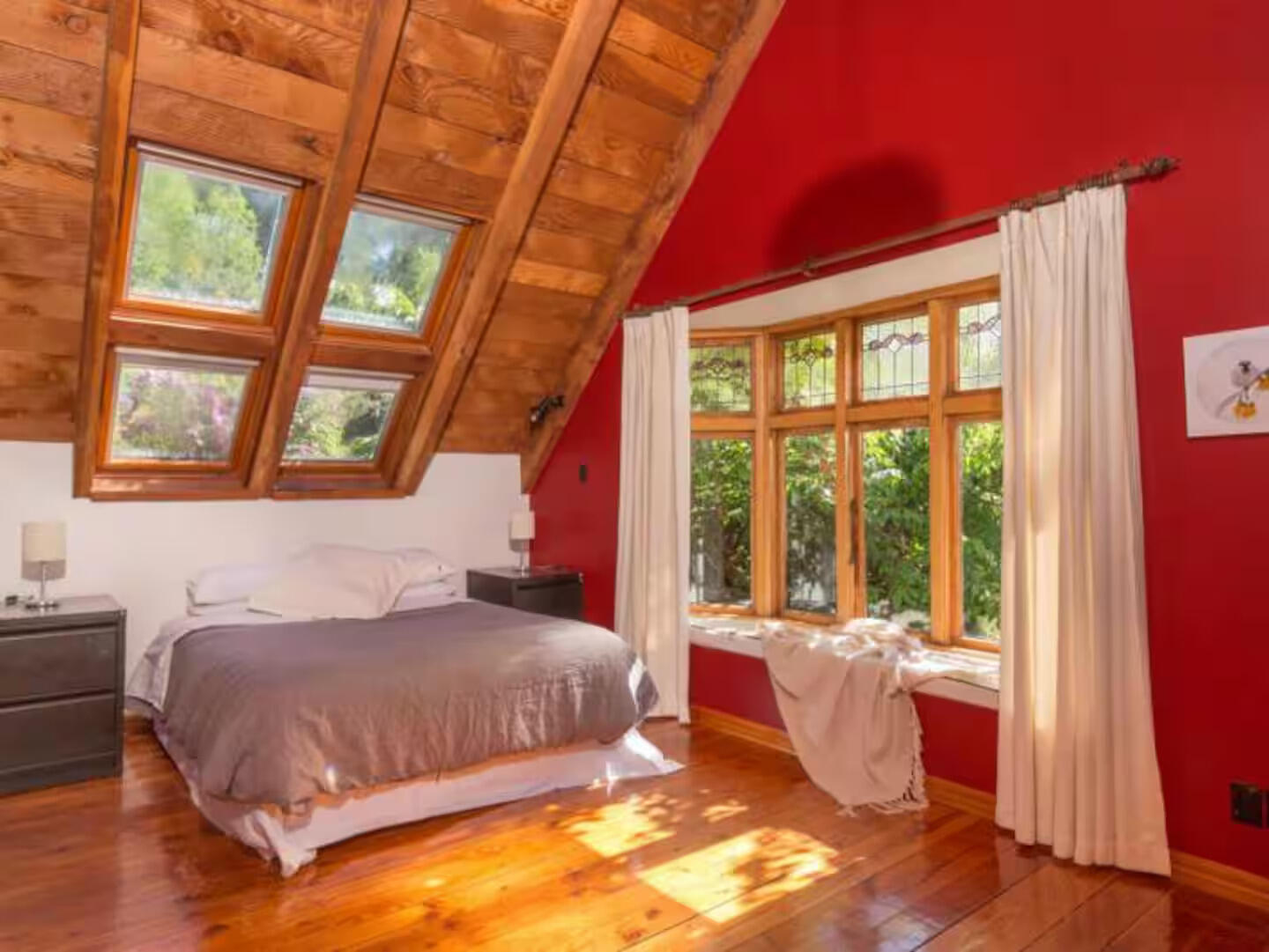 Decluttering · interior & exterior Styling · Property Staging Attic bedroom with skylights, red walls, and a single bed with natural light flooding in